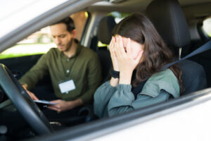 A student driver with her head in her hands after a car accident. Can you sue a minor for a car accident in Connecticut?
